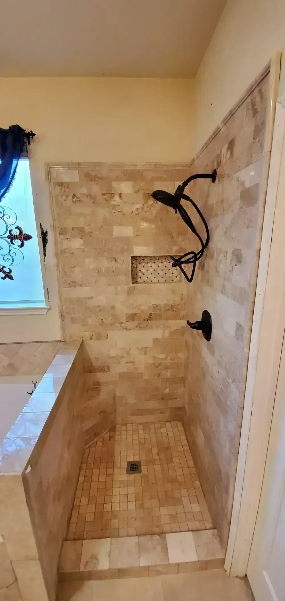 Travertine shower with built-in bench by BNB Concepts