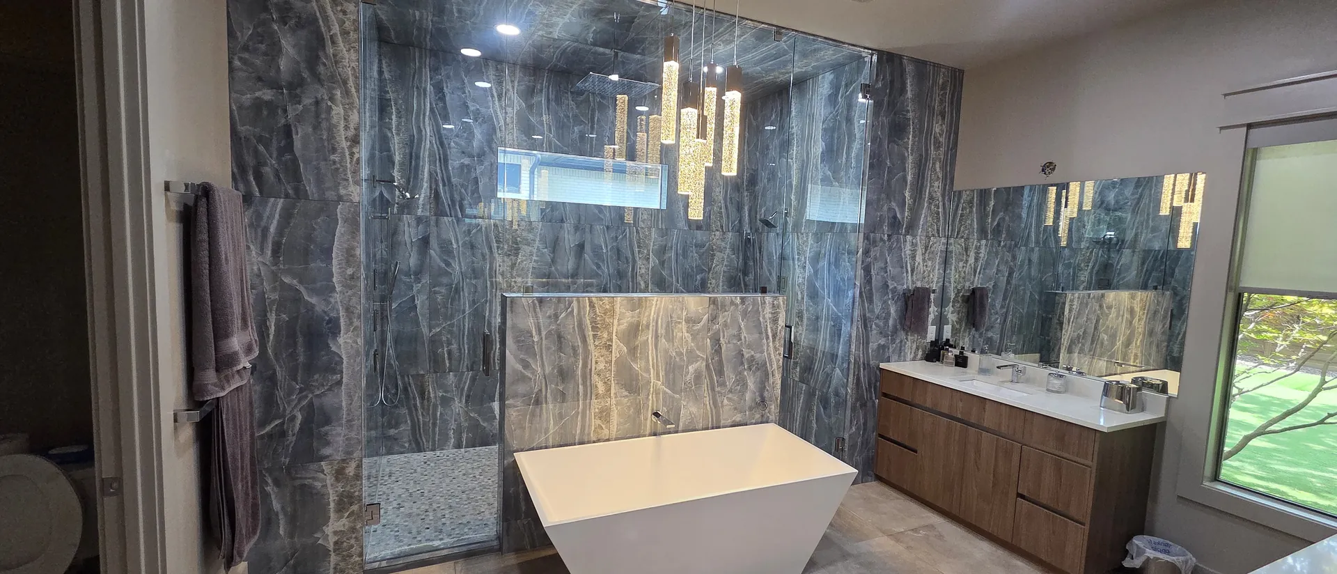 Marble primary bathroom with freestanding tub by BNB Concepts